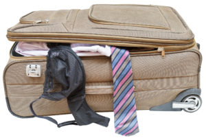 suitcase with fell out male tie and female bra